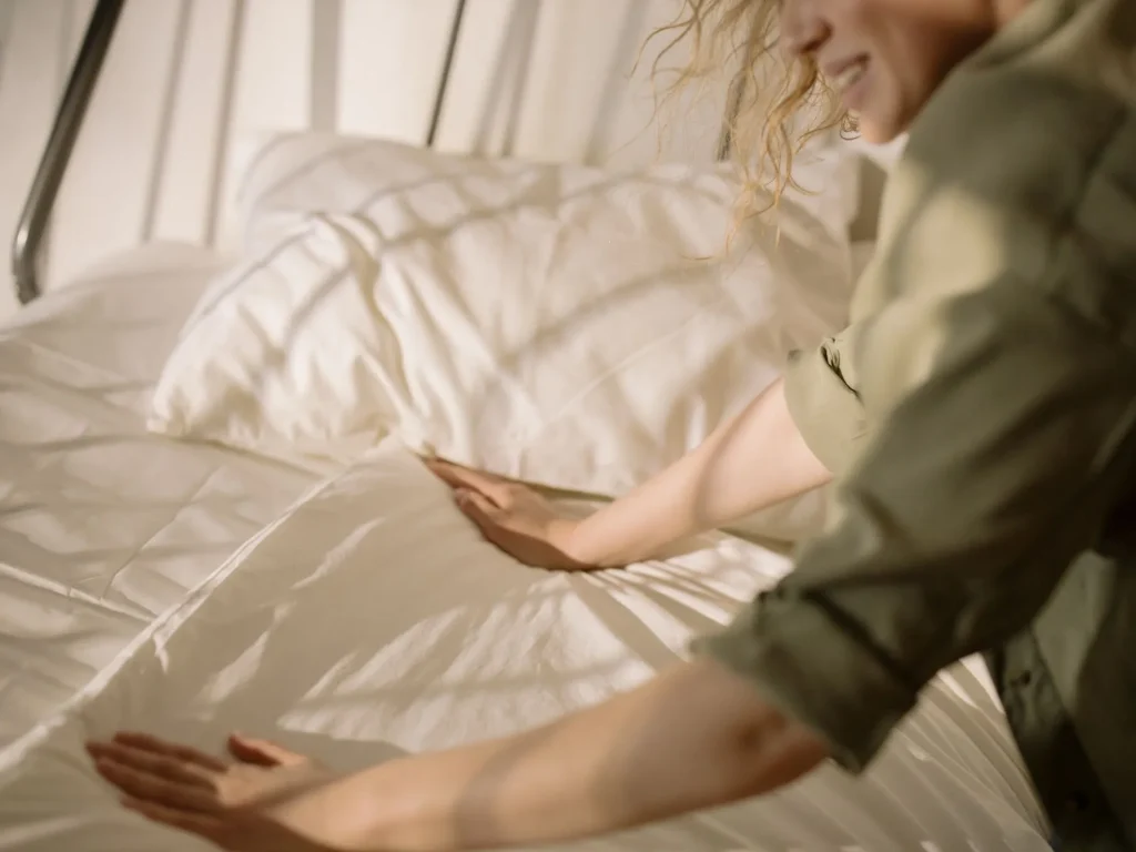 Homeowner folding white cotton sheets