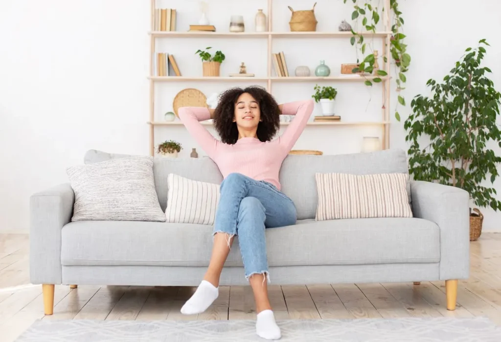 Woman relaxing on couch in recently cleaned living room